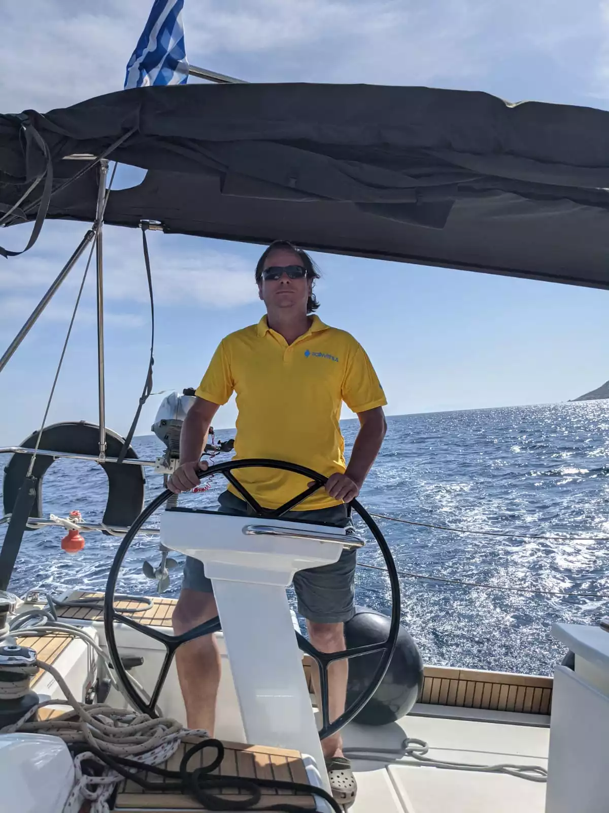 Skipper Thorsten steuert ein Segelboot im Sailwithus-T-Shirt
