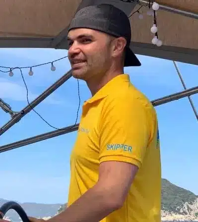Skipper Kevin steuert ein Segelboot im Sailwithus-T-Shirt