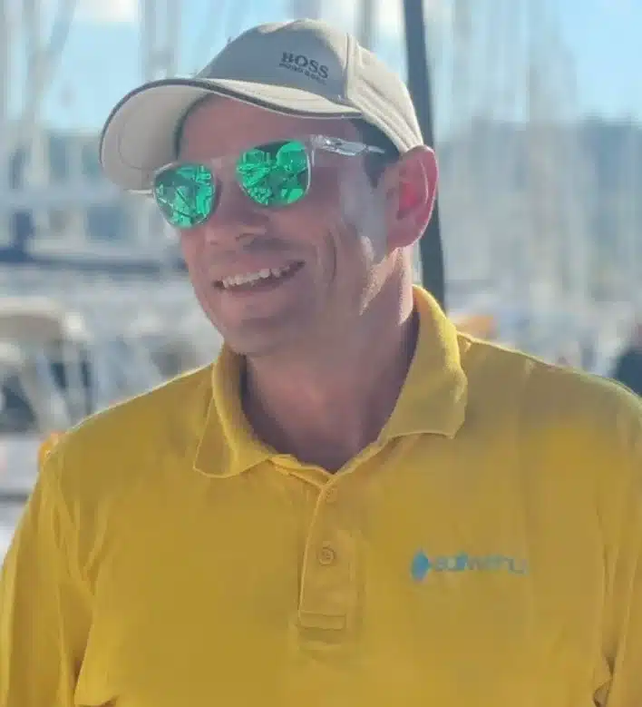 Skipper Axel steuert ein Segelboot im Sailwithus-T-Shirt