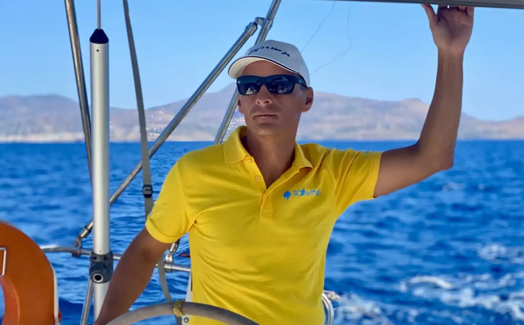 Skipper Gregor steuert ein Segelboot im Sailwithus-T-Shirt