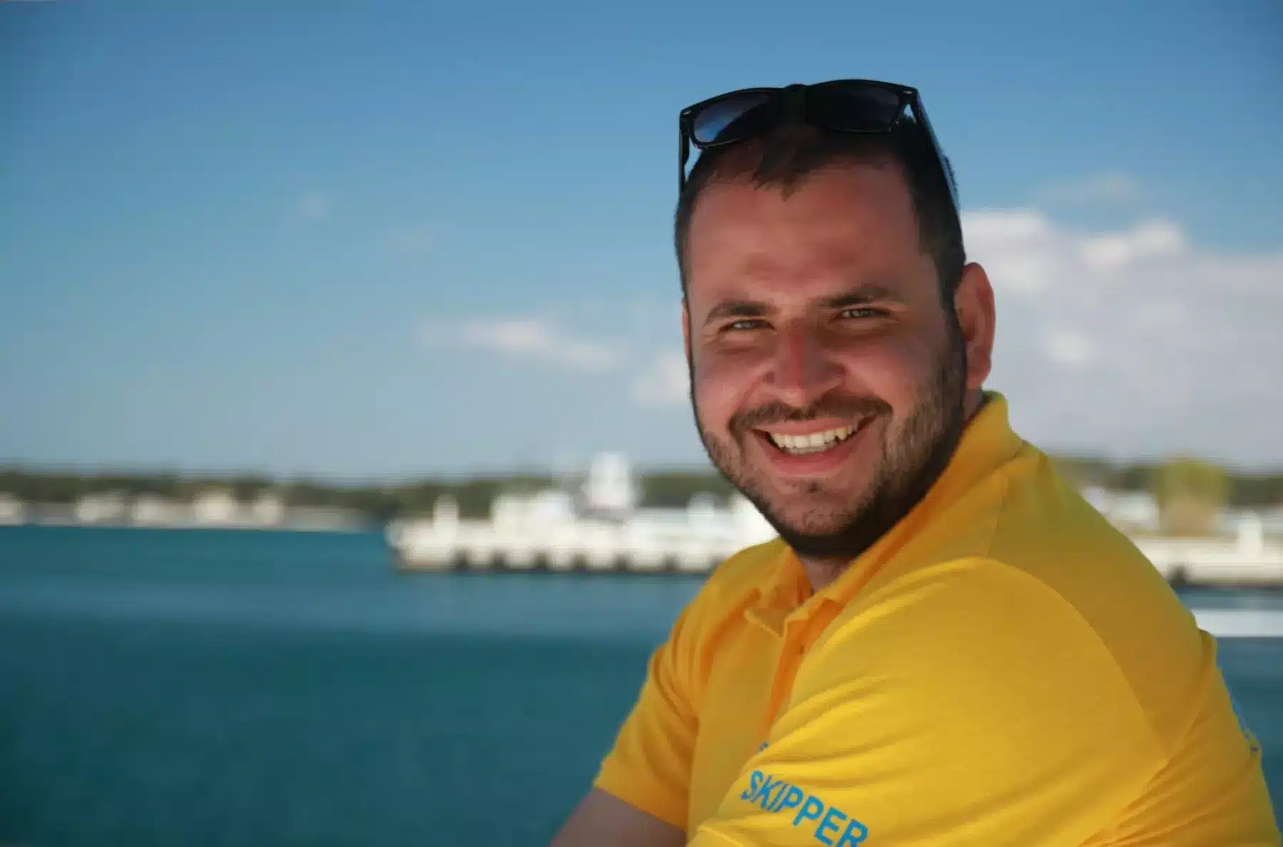 Skipper Jürgen steuert ein Segelboot im Sailwithus-T-Shirt