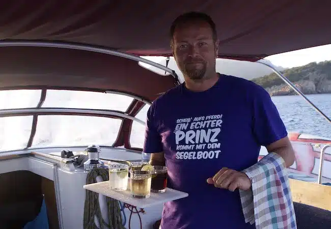 Skipper Markus steuert ein Segelboot im Sailwithus-T-Shirt