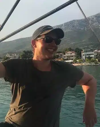 Skipper Matthias steuert ein Segelboot im Sailwithus-T-Shirt