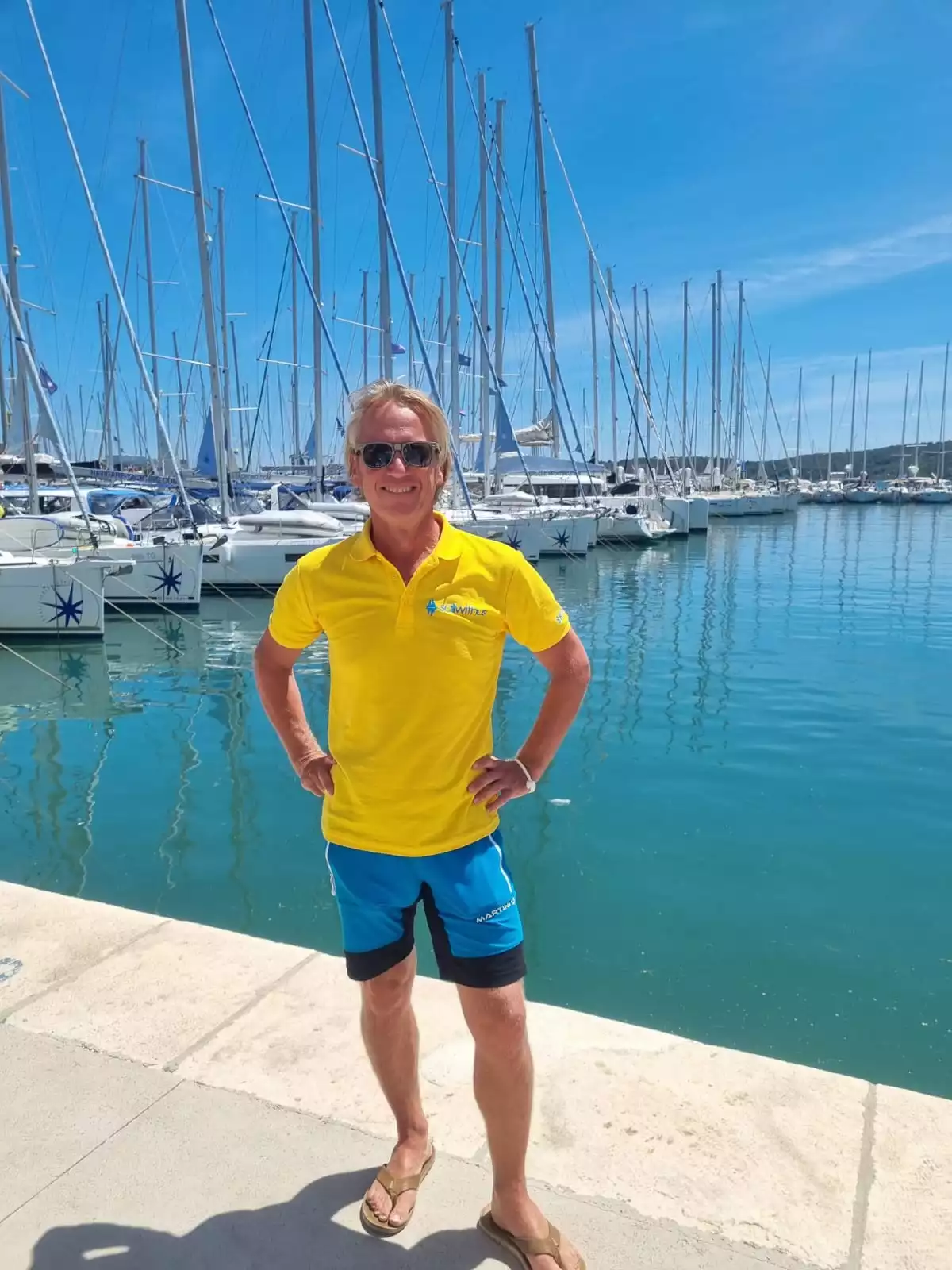 Skipper Rainer steuert ein Segelboot im Sailwithus-T-Shirt
