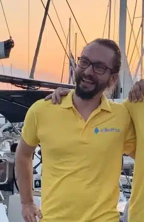 Skipper Manuel steuert ein Segelboot im Sailwithus-T-Shirt