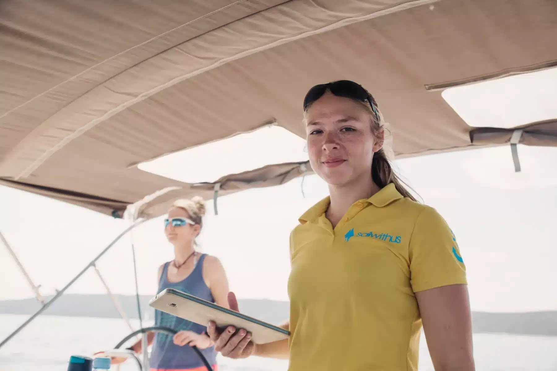 Skipperin Nadja steuert ein Segelboot im Sailwithus-T-Shirt