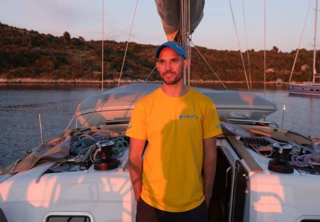 Skipper Carl steuert ein Segelboot im Sailwithus-T-Shirt