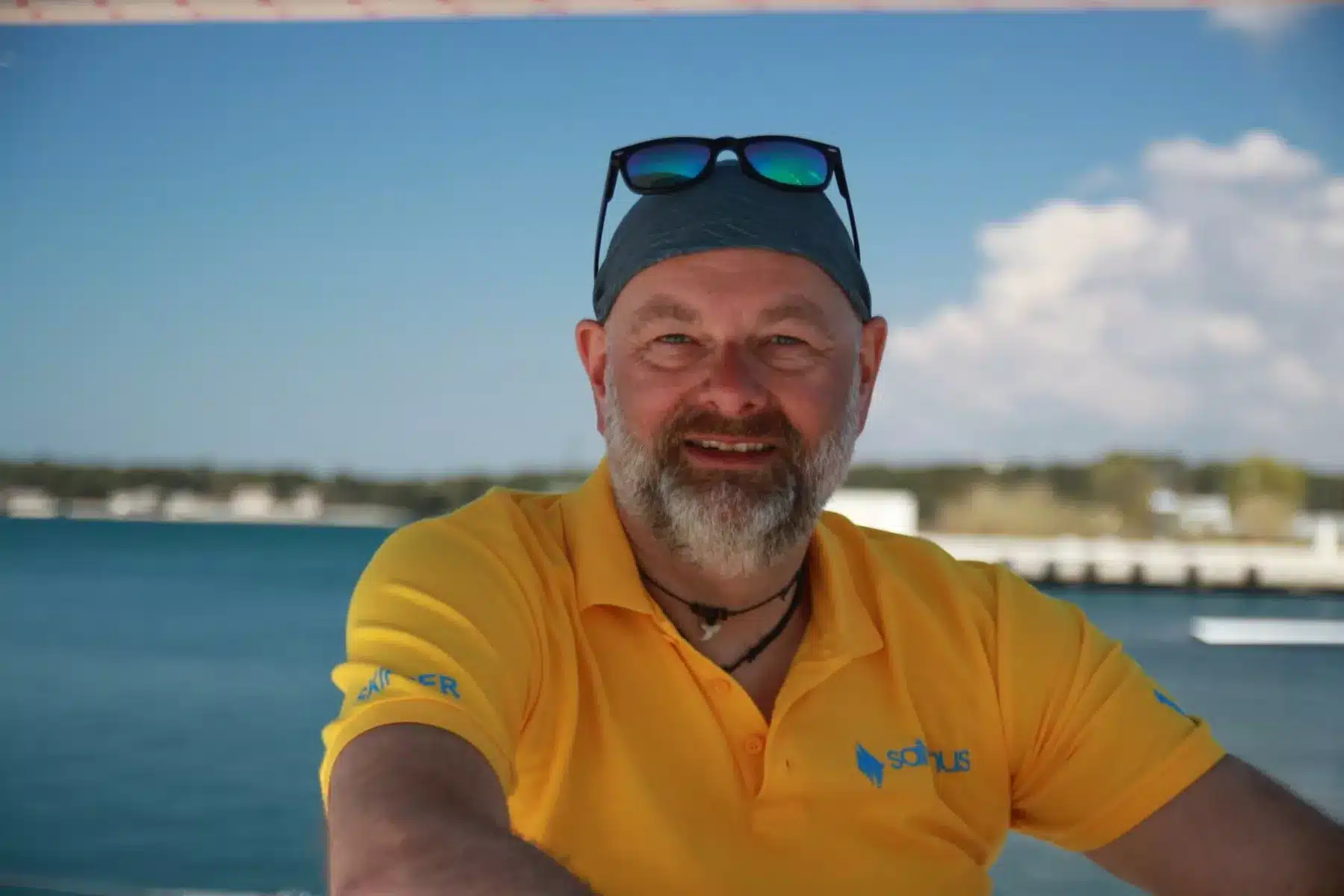 Skipper Matthias steuert ein Segelboot im Sailwithus-T-Shirt