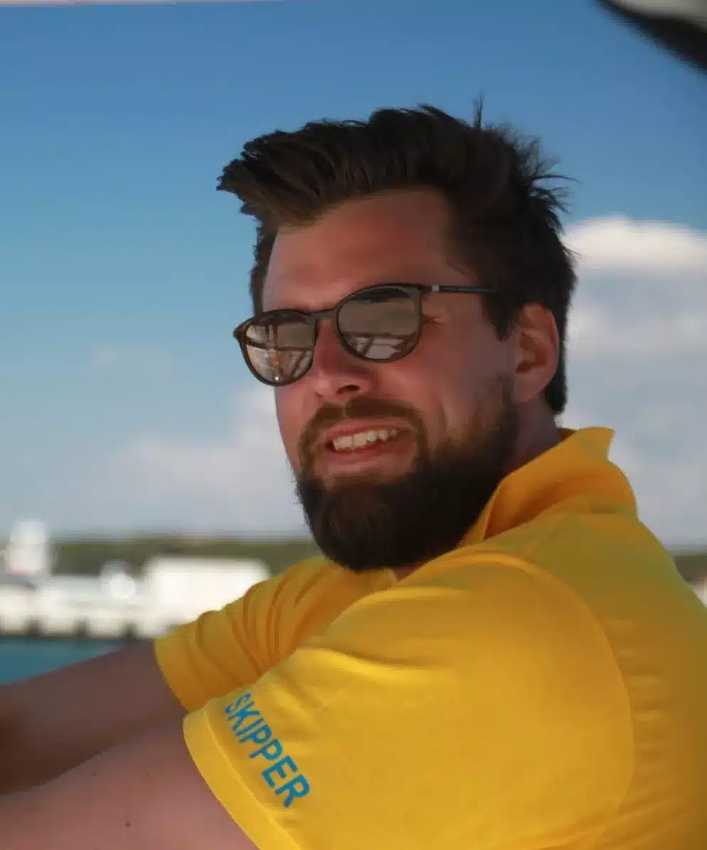 Skipper Philip steuert ein Segelboot im Sailwithus-T-Shirt