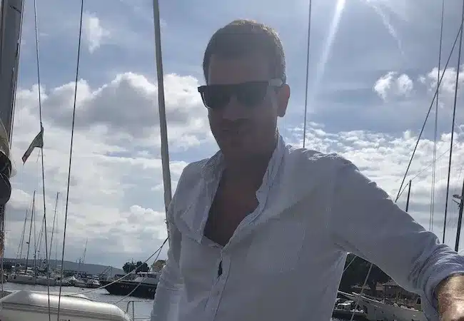 Skipper Stefan steuert ein Segelboot im Sailwithus-T-Shirt