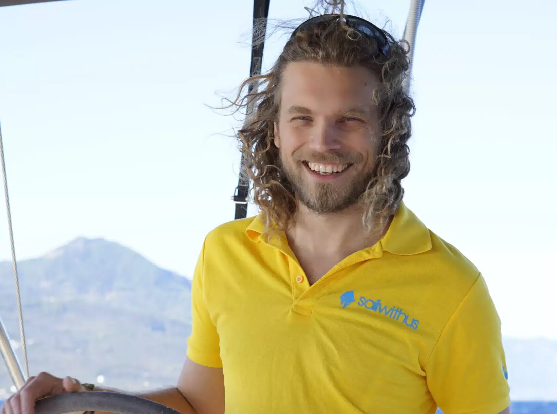 Skipper Torben steuert ein Segelboot im Sailwithus-T-Shirt