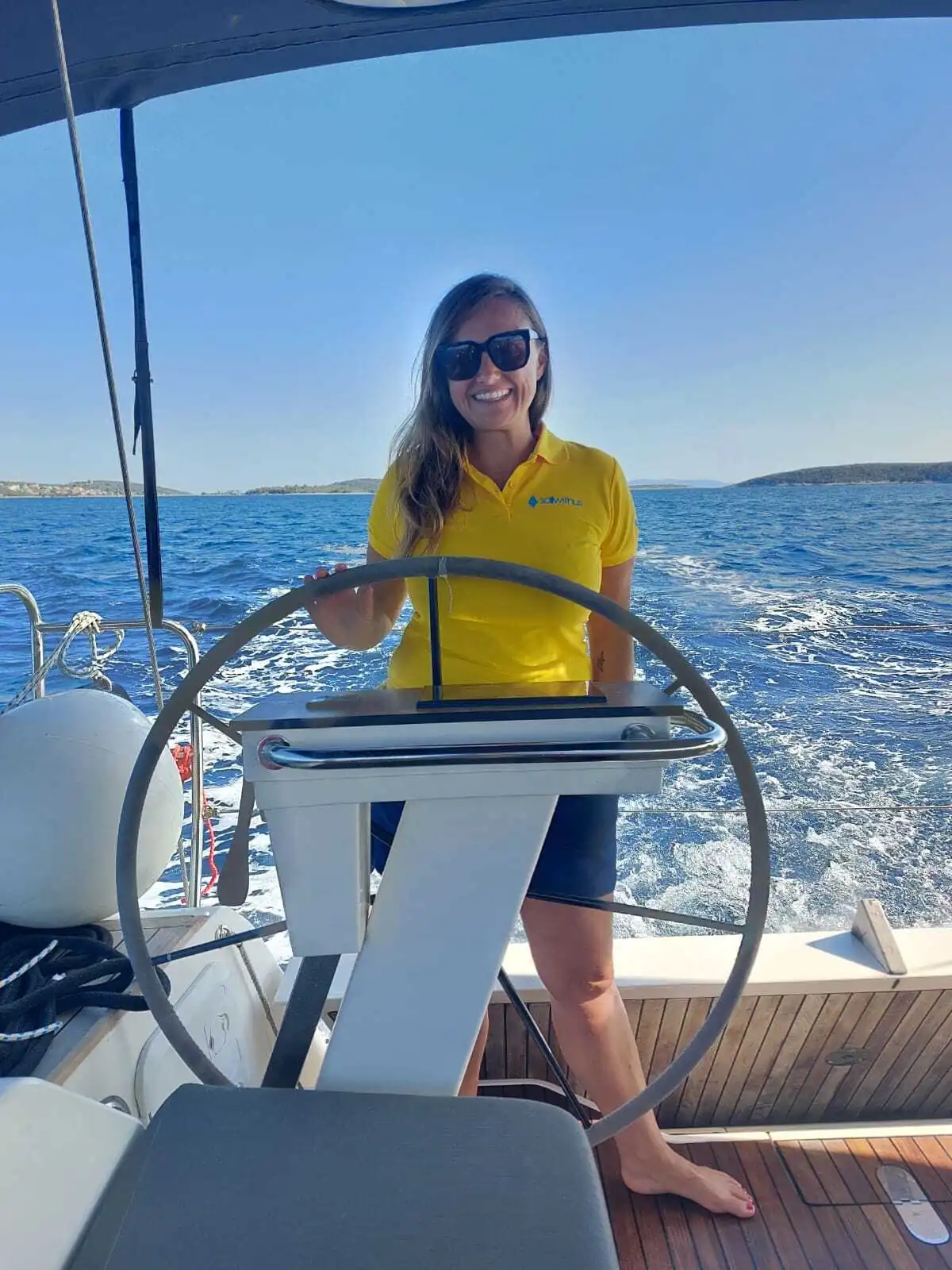 Skipper Aneta steuert ein Segelboot im Sailwithus-T-Shirt