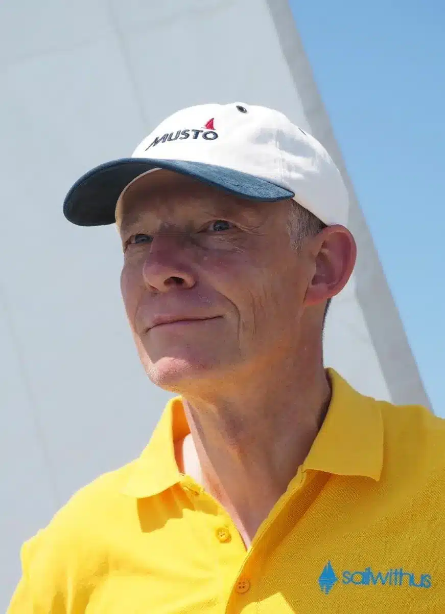 Skipper Oliver steuert ein Segelboot im Sailwithus-T-Shirt