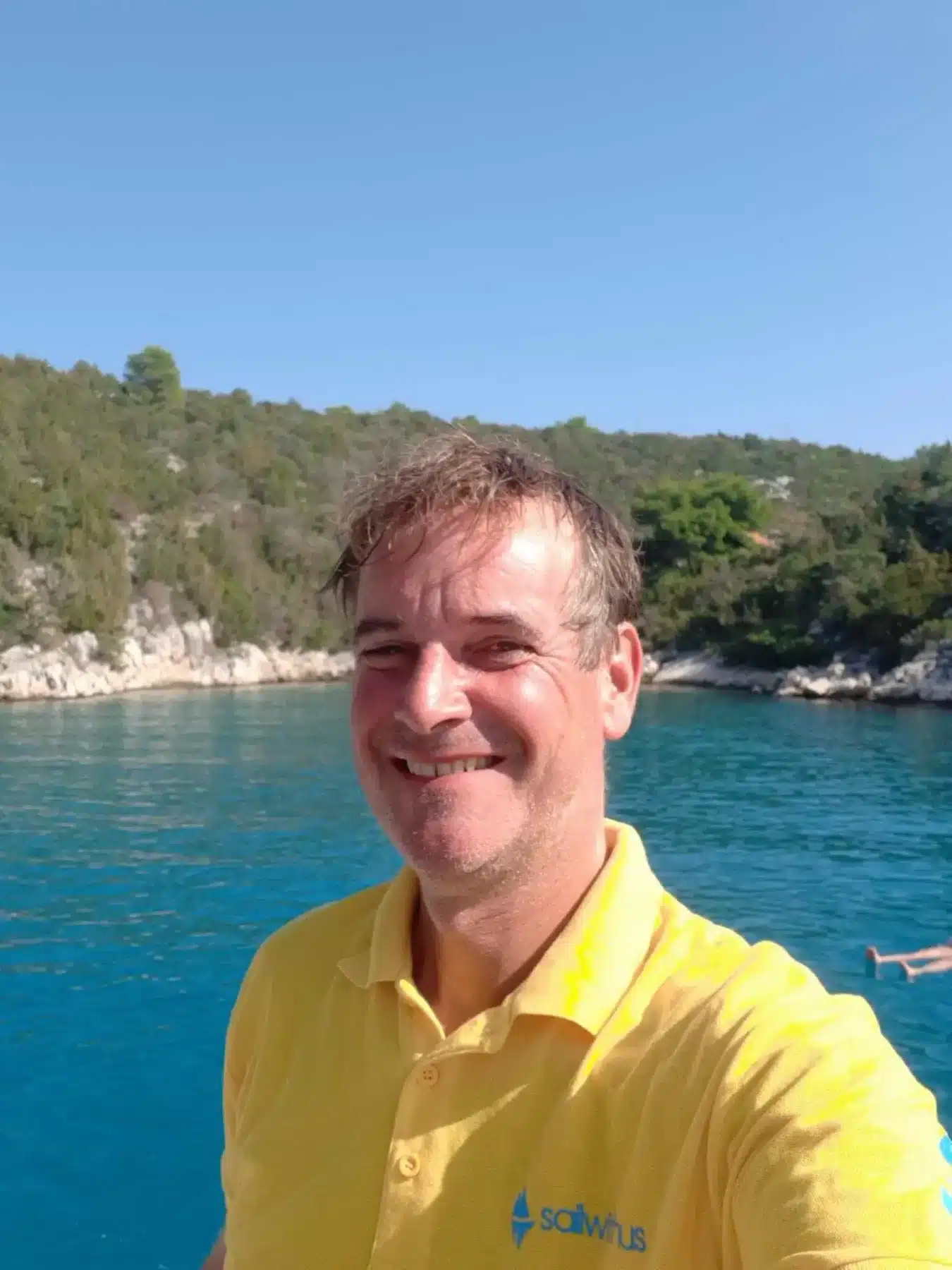 Skipper Marco steuert ein Segelboot im Sailwithus-T-Shirt