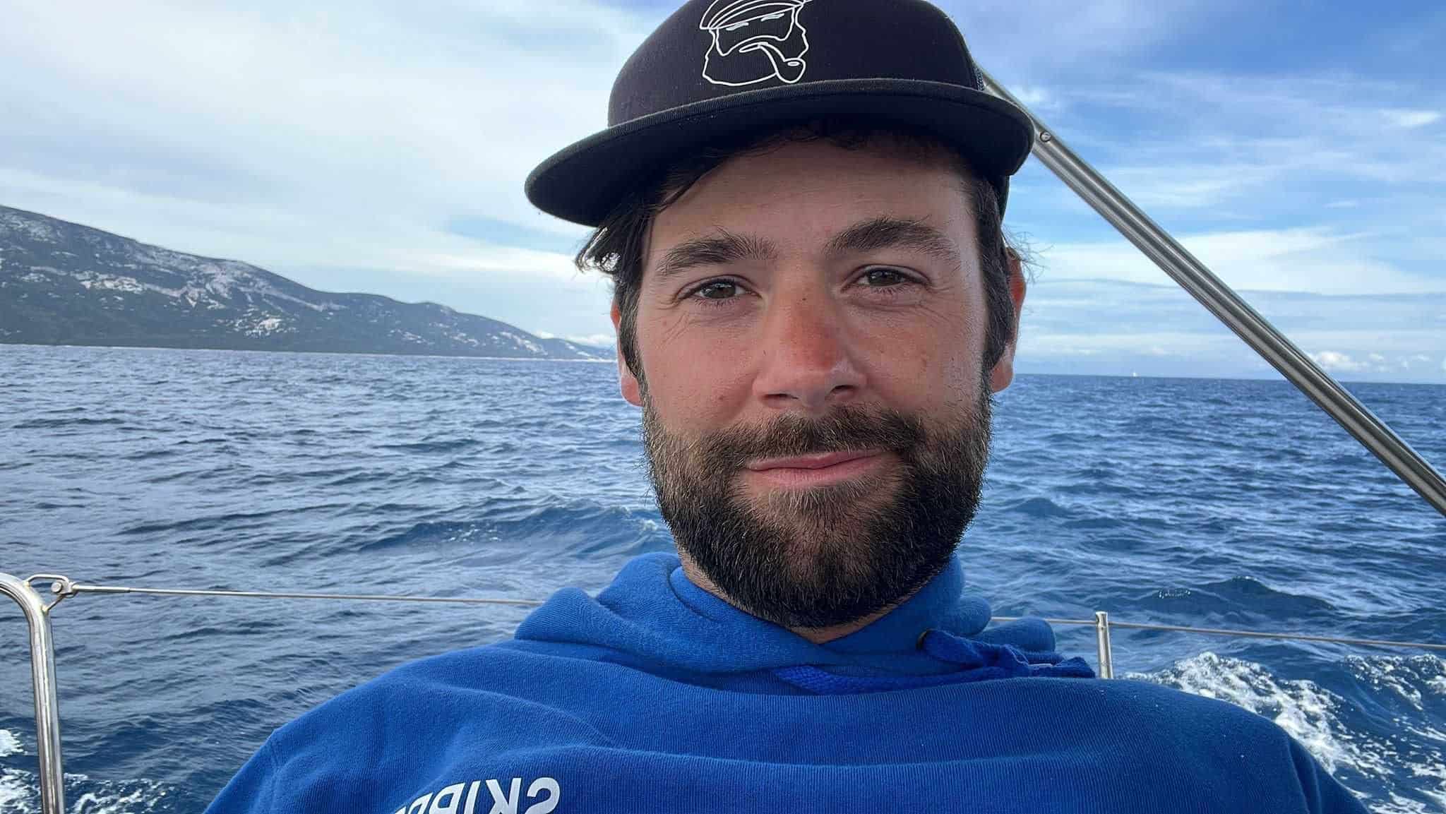Skipper Matthias steuert ein Segelboot im Sailwithus-T-Shirt