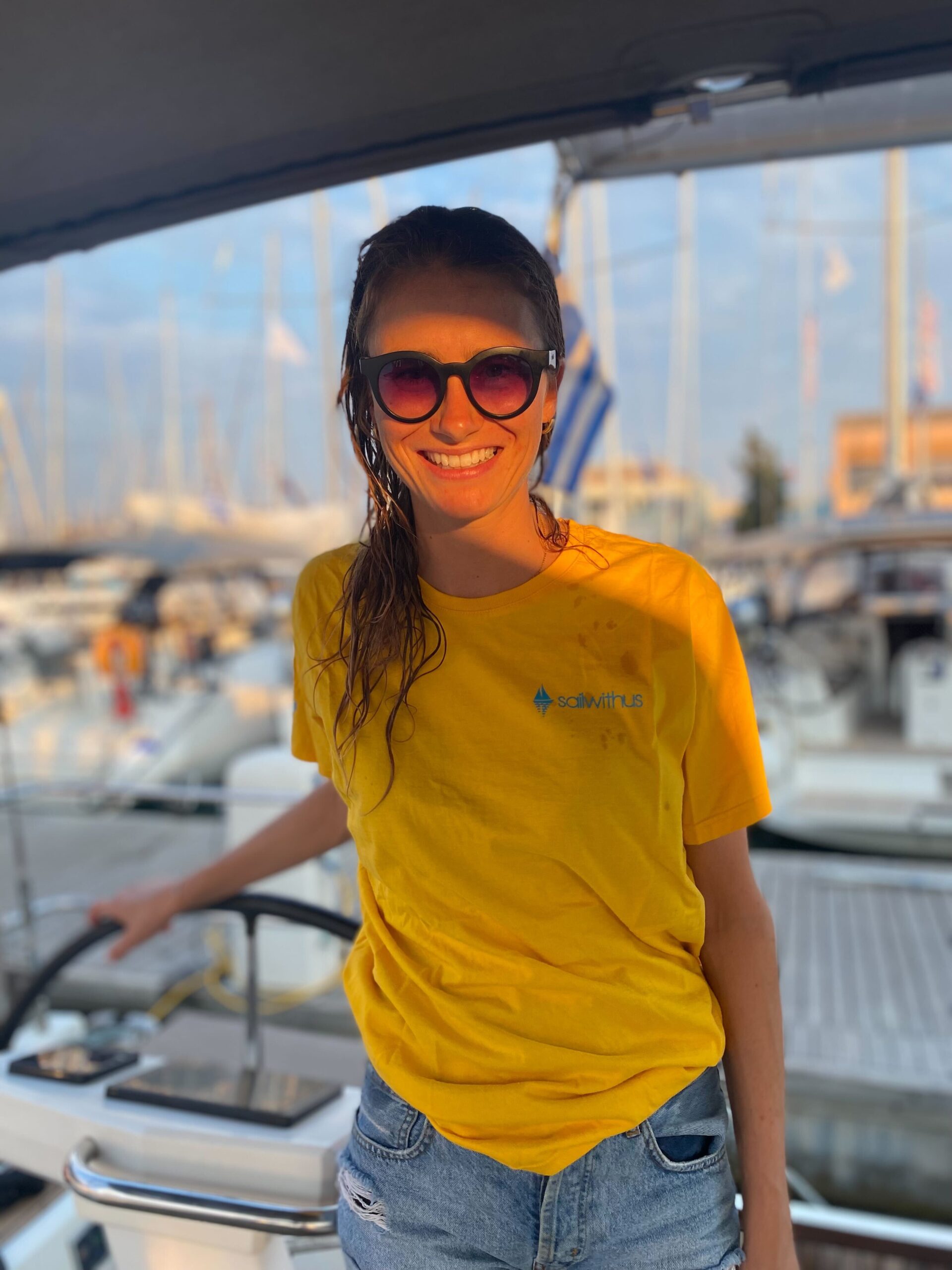 Skipperin Eva steuert ein Segelboot im Sailwithus-T-Shirt