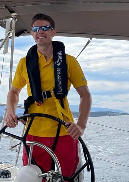 Skipper Mathias steuert ein Segelboot im Sailwithus-T-Shirt