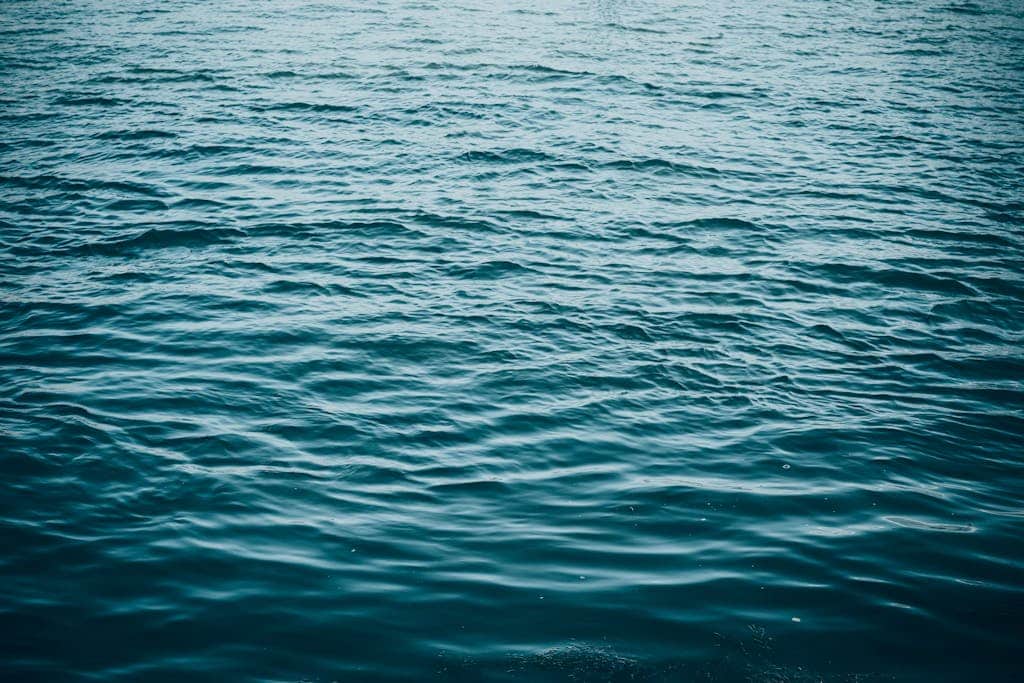 A serene view of blue ocean waves creating a calming texture on the water's surface. Segeln und Windrichtungen: So navigierst du wie ein Profi